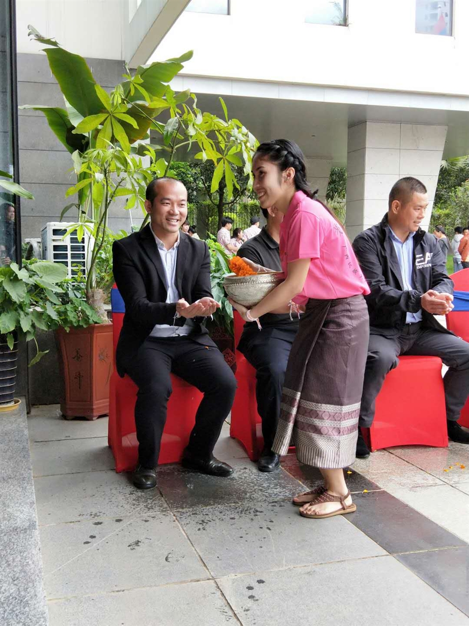 老撾駐廣西留學(xué)生代表將浸有花瓣的香水灑客人的手上，表示對(duì)嘉賓的美好祝福（圖一）